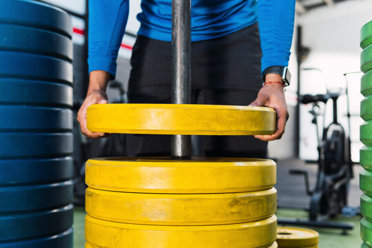 Athlete removing weight plates in gym