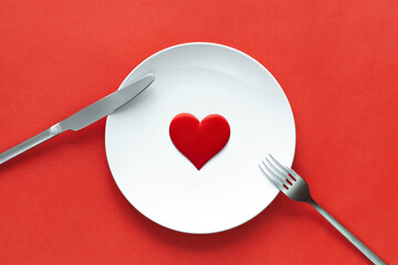 White plate with red heart, love concept, symbol. Valentine day card. Romantic date