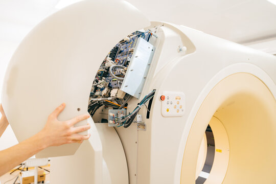 engineer removes cover of a computer tomograph. 