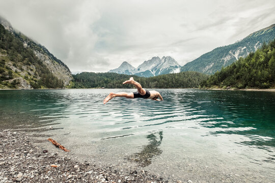 Man diving in Blindsee lake by Mieming Range, Tirol, Austria