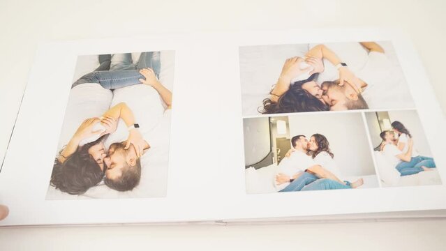 flipping through the pages of a photobook with a family pregnancy photo shoot. 