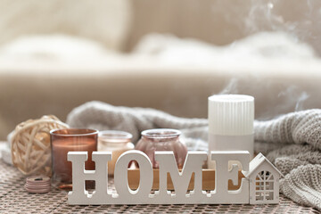 Close up decorative word home on blurred background with candles.