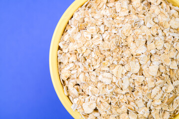 Raw oatmeal in small yellow container
