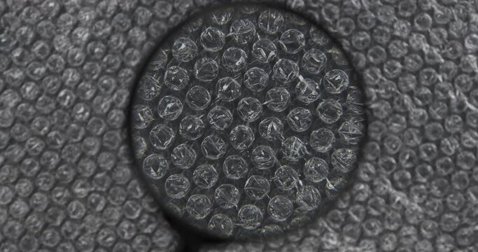 Research, analysis of polyethylene bubble wrap film through a magnifying glass. Rotating bubble wrap to protect the product. Bubble wrap, background and texture