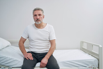 Cheerless mature man seated in hospital ward