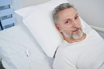 Man receiving supplemental oxygen through nose tubes