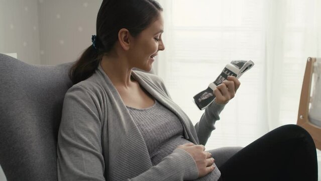 Close up video of caucasian woman in advanced pregnancy browsing ultrasound scan in baby's room. Shot with RED helium camera in 8K.
