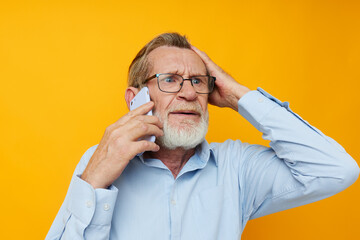 Obraz premium Portrait of happy senior man talking on the phone emotions isolated background