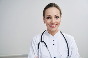 Joyous young doctor posing for camera in workplace