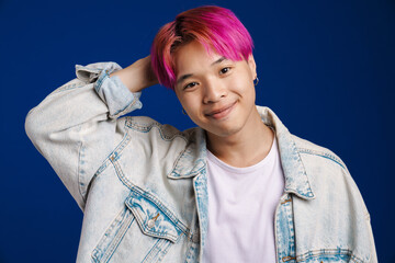Asian boy with pink hair smiling and looking at camera