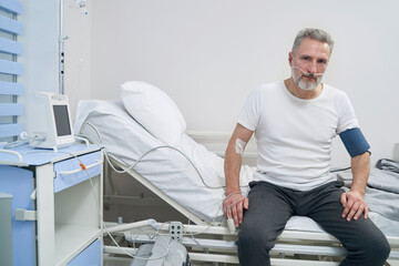 Adult male patient sitting connected to oxygen concentrator
