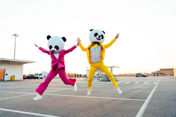 Storytelling image of a couple wearing giant panda head. Man and woman celebrating outdoor and...