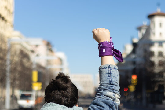 Unrecognizable woman raising her fist in the street.