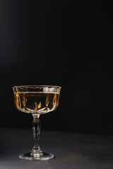 Glass of whiskey or other alcohol liquor served in a glass over black background Vintage glass of hard liquor.
