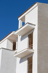 Building in construction white and orange with a blue sky. The owners must be waiting to sign the mortgage.