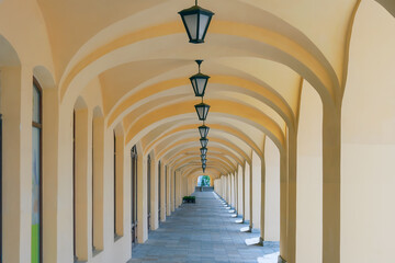 Arched colonnade with hanging lanterns. Perspective. Summer. Day