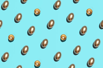 Creative Easter pattern. Golden eggs and eggshells against  vibrant blue background. 