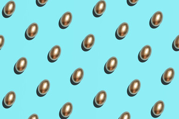 Golden eggs pattern against bright blue background. Creative Easter layout. 
