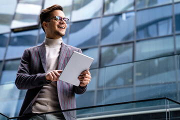 Portrait of successful man using digital tablet in urban background. Business people concept