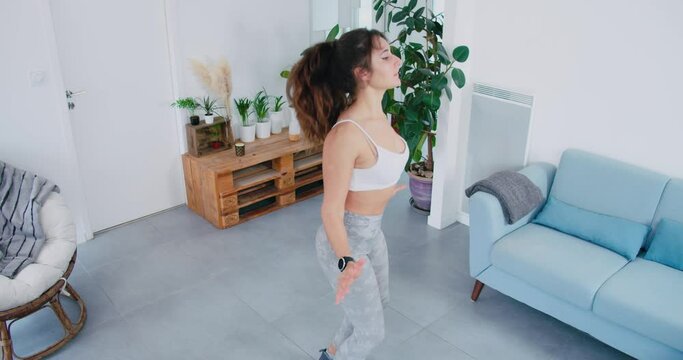 Fit Attractive Woman Doing Jumping Jacks In Her Home, Handheld View