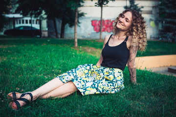 Curly-haired woman sitting on the grass