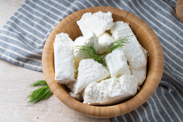 Traditional homemade salted cottage cheese cheese in a wooden bowl