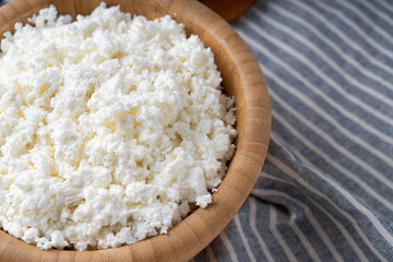 Traditional homemade cottage cheese in a wooden bowl