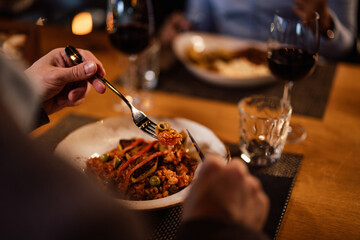 Closeup picture of a plate of spaghetti, being put on a fork, to be eaten.