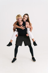 European man and woman in sportswear piggybacking and laughing