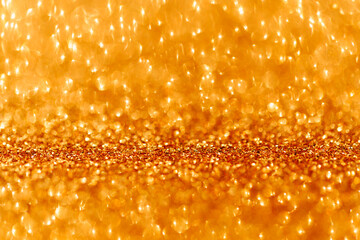 Abstract blurred glitter background golden color. Selective focus with bokeh effect.