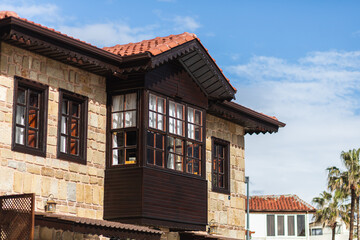 Close-up of an ancient stone building with a wooden balcony and windows