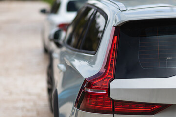 Macro view of modern silver car xenon lamp taillight, bumper, rear trunk lid. Exterior of a modern car.