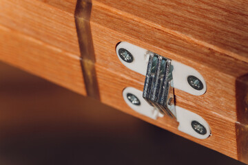 Stainless door hinges on wooden swing door.