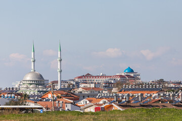 Obraz premium Colorful Turkish streets with low houses, barrels of hot water on the roof and solar panels, city mosque and hotels
