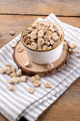 Cicerchia or indian pea on a ceramic bowl with napkin on natural wooden background, close up. Legumes known as Lathyrus Sativus, Chickling Vetch, Blue Sweet Pea made in Puglia