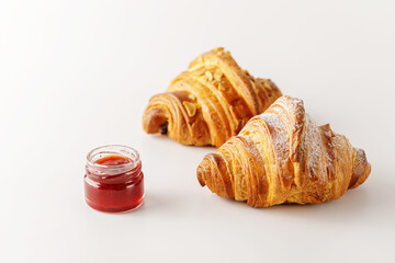 Delicious fresh croissants with strawberry jam isolated on white background.