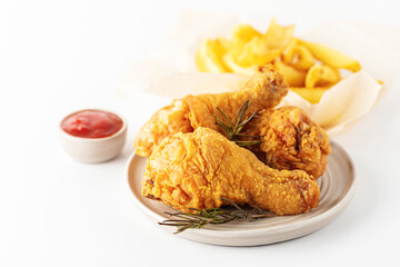 Fried crispy chicken legs and french fries with ketchup isolated on white background. Close-up. Empty space for text.