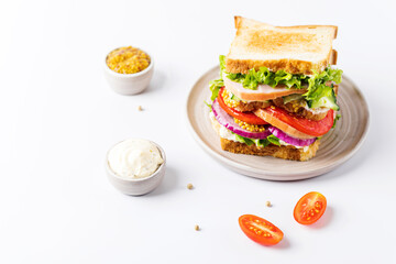 Fresh tasty sandwich with ham, tomato and red onion isolated on a white background.