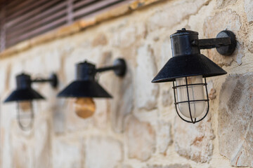 Beautiful street lamps on a stone wall. Background texture of the stone wall of the old castle.