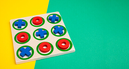 tic-tac-toe board game concept on yellow and green background with copy space - obrazy, fototapety, plakaty