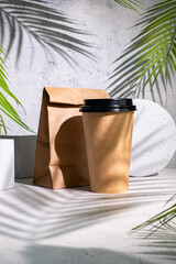 Take away paper coffee cup with lunch bag on grey background