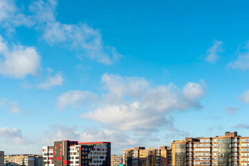 City houses on a background of clouds and blue sky