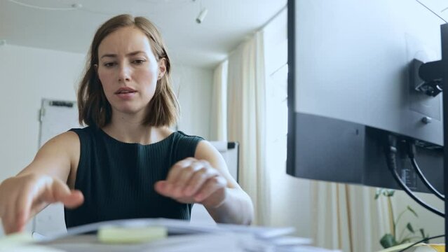 Stressed and hard working young businesswoman and female at office trying to find something lost, ending at giving up and feeling frustrated. Concept: looking after lost or hidden papers and work. 