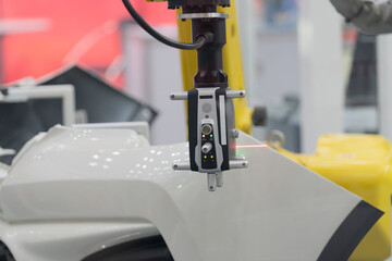 Industrial T-SCAN 3D scanner on robotic arm in automotive industry. Robotic arm installed in automotive factory with T-SCAN 3D scanner technology as technology 4.0