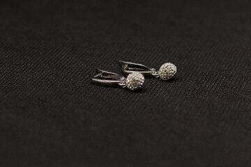 Round silver earrings on a black background
