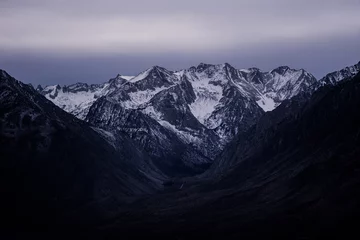 Foto op Aluminium A beautiful view of rocky mountains covered with snow at dusk in the winter © Teddy Caligiuri/Wirestock