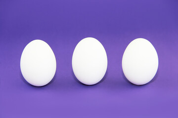 white easter eggs on purple background very peri