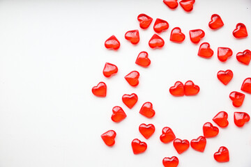 Small red hearts are scattered on a white background. Space for text. The symbol of Valentine's Day. Holiday concept