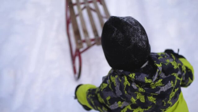 Kid having fun with dad, falling of the sledge