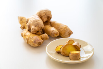 Ginger root and next to cut ginger on plate.
